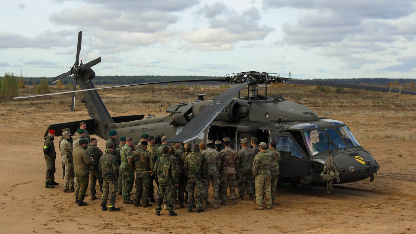 Multinational NATO troops examining a UH-60 Black Hawk during Exercise Iron Wolf in Lithuania, October 2024